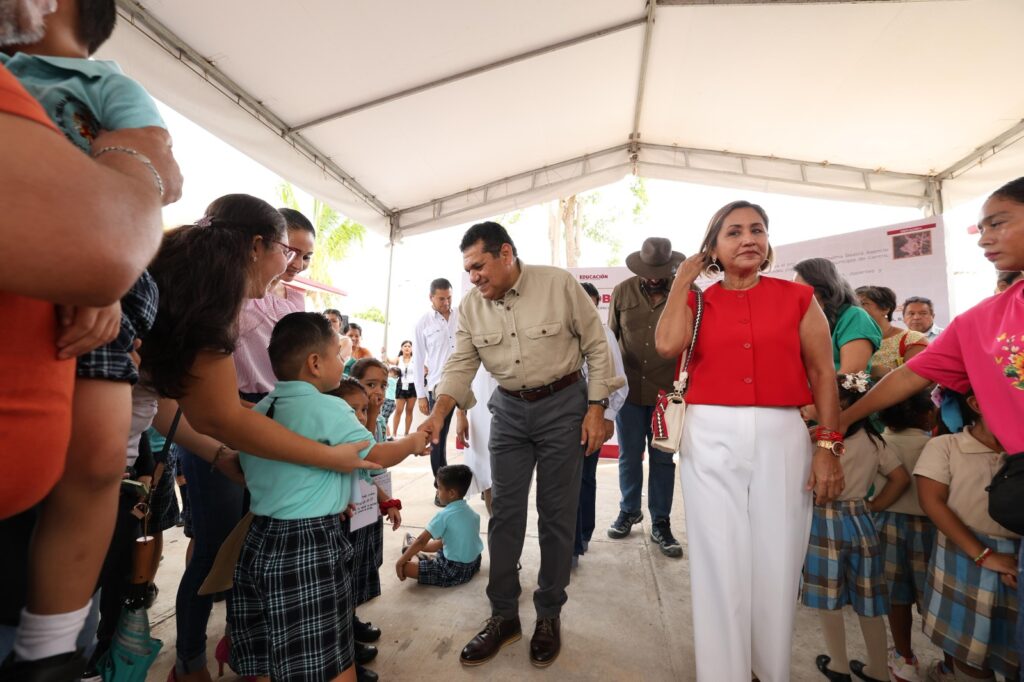 Javier May y Yolanda Osuna saludan a niños durante entrega de obra educativa.
