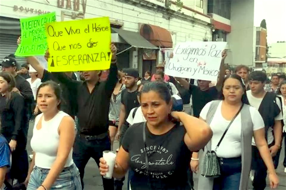 Manifestantes marchan por las calles de Uruapan con pancartas que exigen paz en México.