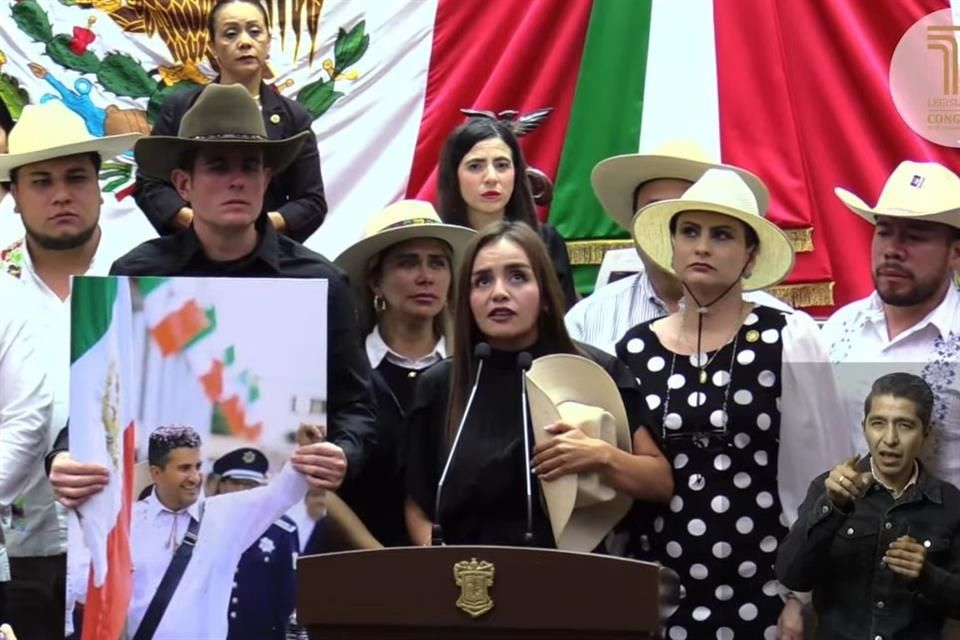 Grecia Quiroz levanta la mano al rendir protesta como presidenta municipal de Uruapan.