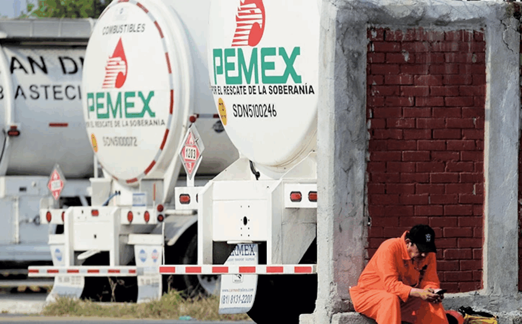 Obras de construcción en la Planta de Coque de Pemex con grúas de gran tonelaje instalando infraestructura industrial en una refinería, bajo cielo despejado y con trabajadores supervisando la maniobra.