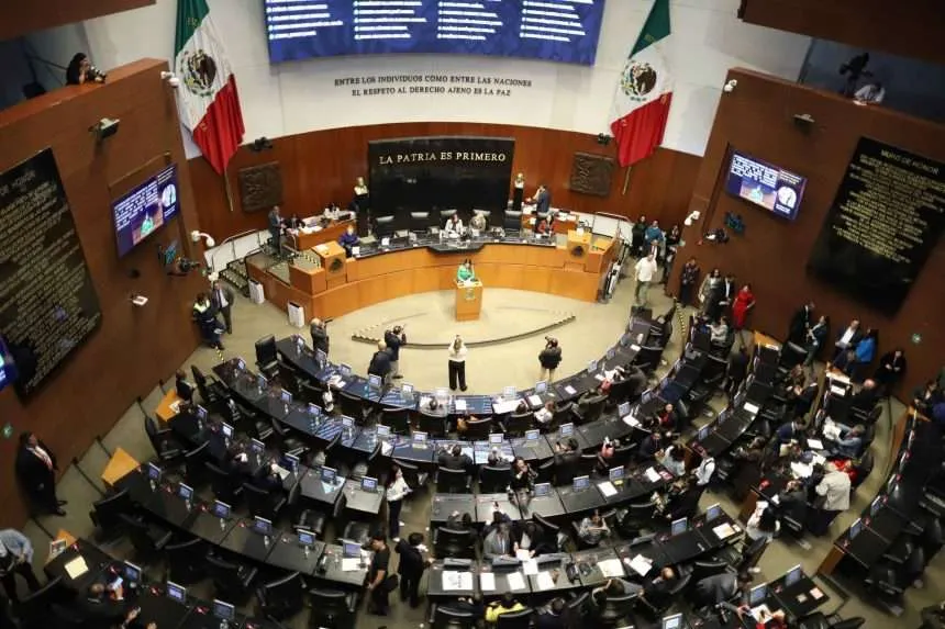 Vista panorámica del Pleno del Senado de la República en México durante una sesión legislativa, mostrando los escaños dispuestos en semicírculo y el muro de honor al fondo.