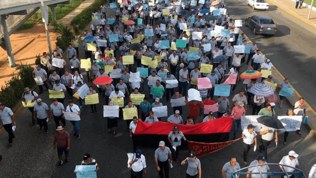 Contingente de trabajadores del STAIUJAT marchando sobre una avenida de Villahermosa con pancartas y banderas rojinegras en protesta por el tope salarial 2026.