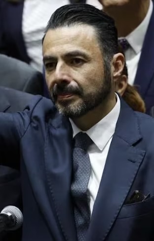 Funcionario federal levanta la mano durante sesión en el pleno de la Cámara de Diputados tras rendir protesta como titular del órgano de fiscalización.