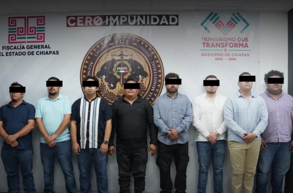 Ocho agentes de la FGE de Chiapas detenidos y presentados ante la institución por el caso de tortura en Tuxtla Gutiérrez, con el letrero "Cero Impunidad" visible al fondo